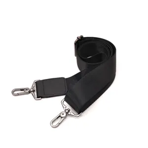 Dettaglio cinturino di ricambio per borsa in nylon nero con ganci metallici e cuscinetto.