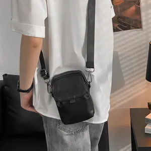 Pequeño bolso cruzado negro informal y minimalista para hombre y mujer, vista de estilo.