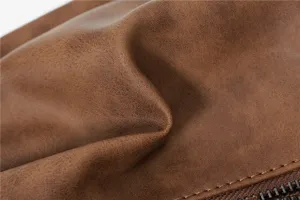 Brown matte leather chest bag detail close-up showing fine stitching and smooth zipper texture.