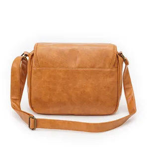 Close-up detail view of the brown PU leather crossbody bag, showcasing metal hardware and buckle.