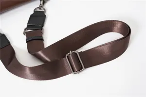 Brown canvas shoulder bag strap detail with adjustable metal buckle and durable hardware.