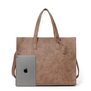 Detailed view of brown PU leather tote bag with handle and shoulder strap for daily commuting.