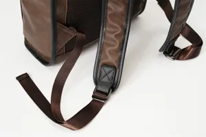 Close-up detail of mens brown PU leather backpack strap and back mesh panel, durable retro design.