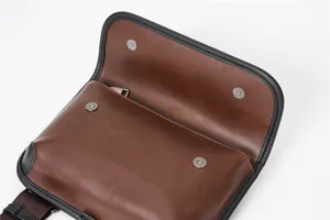 Detailed view of brown PU leather crossbody chest bag interior flap with magnetic snap buttons.