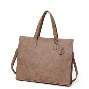 Detail view of the brown PU leather horizontal tote bag showing texture, handles, and strap.