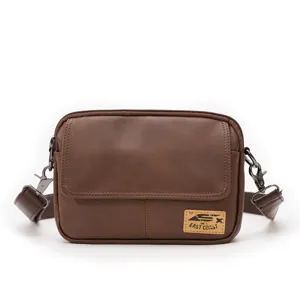 Brown faux leather messenger bag detail showing textured surface, flap closure and hardware.