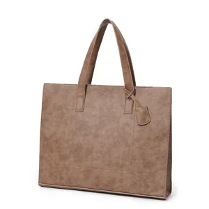 Detail view of the brown PU leather tote bag showing texture, dual handles, and structured shape.