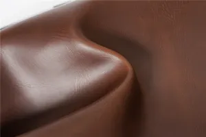 Close-up detail of premium brown PU leather featuring soft texture and vintage crazy horse grain.