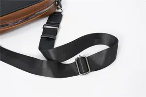 Primo piano del dettaglio della tracolla in nylon regolabile e della fibbia in metallo della borsa.