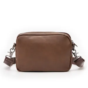 Brown leather rectangular crossbody bag detail shot showing retro messenger design.