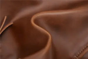 Close-up detail of premium vintage brown leather men business briefcase texture and fine stitching.