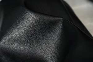 Detailed close-up shot of premium black leather material texture with fine grain finish.
