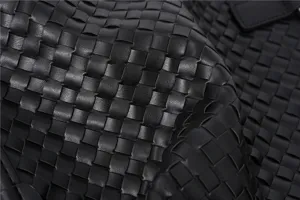 Zwarte geweven lederen tas detailopname, premium mode business handtas textuur weergave.