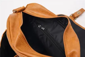 Retro brown leather shoulder bag interior detail showing durable fabric lining and zipper pocket.