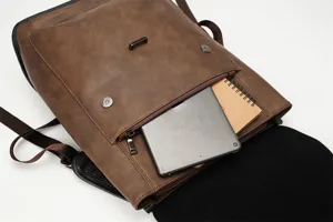 Close-up of brown PU leather vintage backpack front pocket showing inner storage space detail.