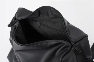 Detailaufnahme einer schwarzen Ledertasche mit Reißverschlussfach und geräumigem Innenraum.