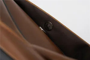 Vista di dettaglio della borsa a tracolla in pelle marrone con chiusura magnetica resistente.