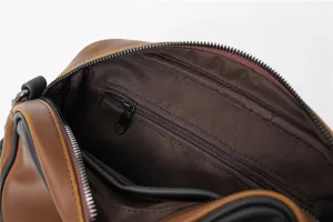 Primo piano che mostra lo spazioso scomparto interno e la tasca con cerniera di questa elegante borsa.