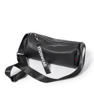 Close-up of the black cylindrical crossbody bag featuring a smooth zipper and branded pull tag.