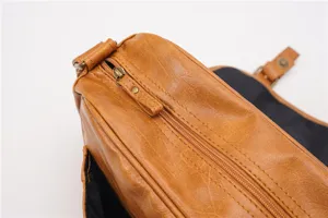 Detailed close-up view of vintage brown PU leather shoulder bag zipper and texture.