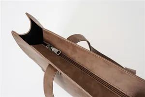 Brown PU leather tote bag detail showing zipper closure and durable shoulder handles.