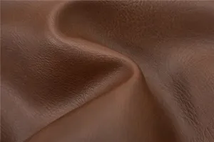 Close-up detail of premium brown leather fabric, showing soft texture and natural folds.