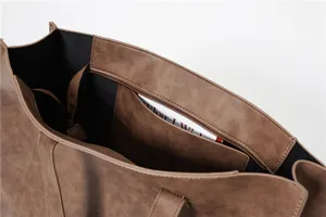 Detail view of brown PU leather tote bag interior showing zipper pocket and spacious design.