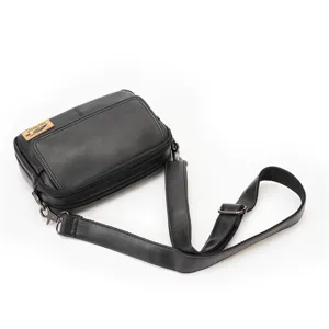 Detail view of black leather crossbody bag, retro square shoulder bag with adjustable strap.