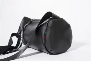 Stylish black cylindrical crossbody bag for men and women, casual lightweight shoulder bag.