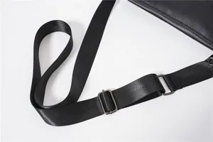 Close-up detail shot of black adjustable shoulder bag strap with durable metal hardware.