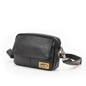 Detail view of the black leather crossbody bag, featuring premium texture and metal buckle.