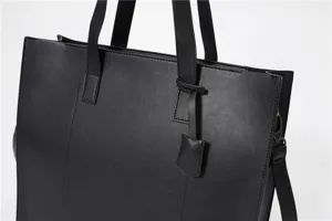 Black PU leather tote bag detail, featuring durable top handles and clean stitching.