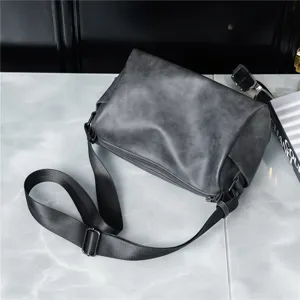 Detailed view of the dark grey cylindrical crossbody bag with adjustable strap and zip closure.