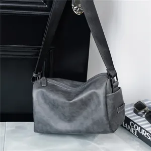Grey cylindrical shoulder bag detail, casual crossbody design with wide strap and zipper.