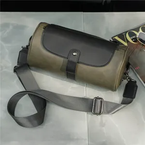 Vintage cylindrical crossbody bag, green and black leather shoulder bag with wide adjustable strap.