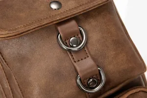 Close-up detail of retro leather men chest bag featuring metal D-rings and snap button hardware.