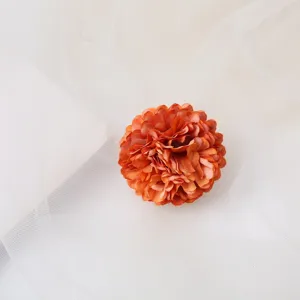 Close-up detail of a 4cm bohemian orange artificial flower hair clip for bridal vacation.