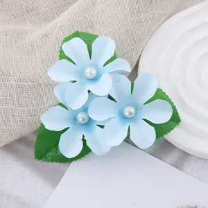 Nahaufnahme der blauen Stoffblumen-Haarspange mit Perlenmitte und filigranem Blattdesign.
