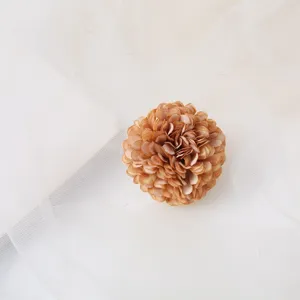 Close-up detail of a brown fabric flower hair clip, bohemian floral accessory for styling.