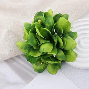 Green artificial flower hair clip detail, multi-layered fabric petals for beach vacation.