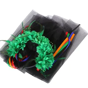 Detailed view of green floral Halloween feather headband with long black mesh veil.
