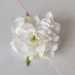 Detail view of white artificial peony flower hair clip, fabric floral hair accessory for women.