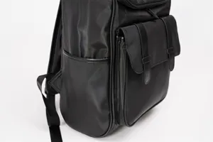 Detailed view of the black backpack showing front pocket, durable strap and sleek design.