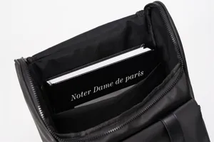 Black fashion casual backpack interior detail shot, large capacity multi-compartment design.