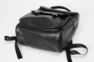 Vista ravvicinata dettagliata dello zaino rétro in pelle PU nera con texture, cinghie e tasca.