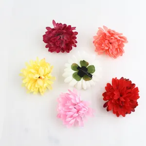 Vue rapprochée de plusieurs pinces à cheveux chrysanthèmes artificiels colorés sur fond blanc.