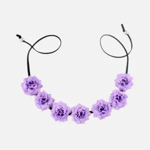 Close-up detail of the purple floral headband, showing the delicate petals and adjustable cord.
