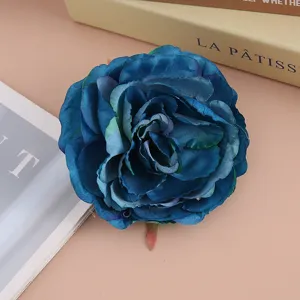 Detailaufnahme einer blauen künstlichen Stoff-Rosenblüten-Haarspange für Fotoshootings.