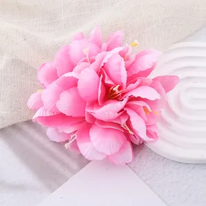 Close-up detail of a vibrant pink artificial flower hair accessory, perfect for tropical beach.