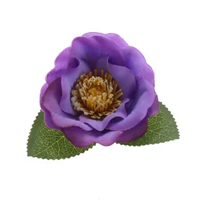 Purple artificial camellia flower head closeup with green leaves for DIY hair accessories craft